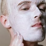 Close-up of a man applying facial cleanser, emphasizing skincare and cleanliness.