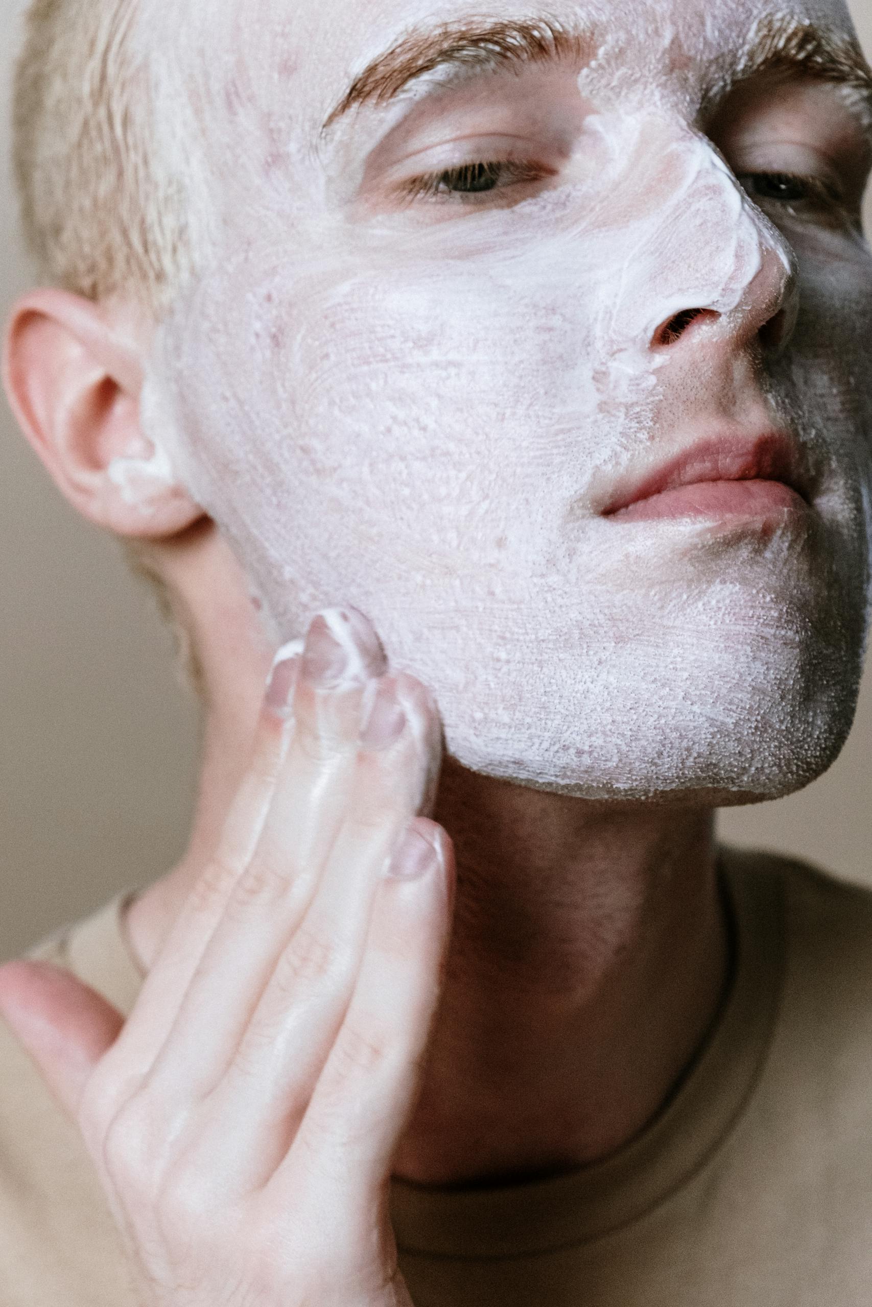Close-up of a man applying facial cleanser, emphasizing skincare and cleanliness.