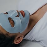 Close-up of a woman wearing a clay face mask, promoting self-care and relaxation.