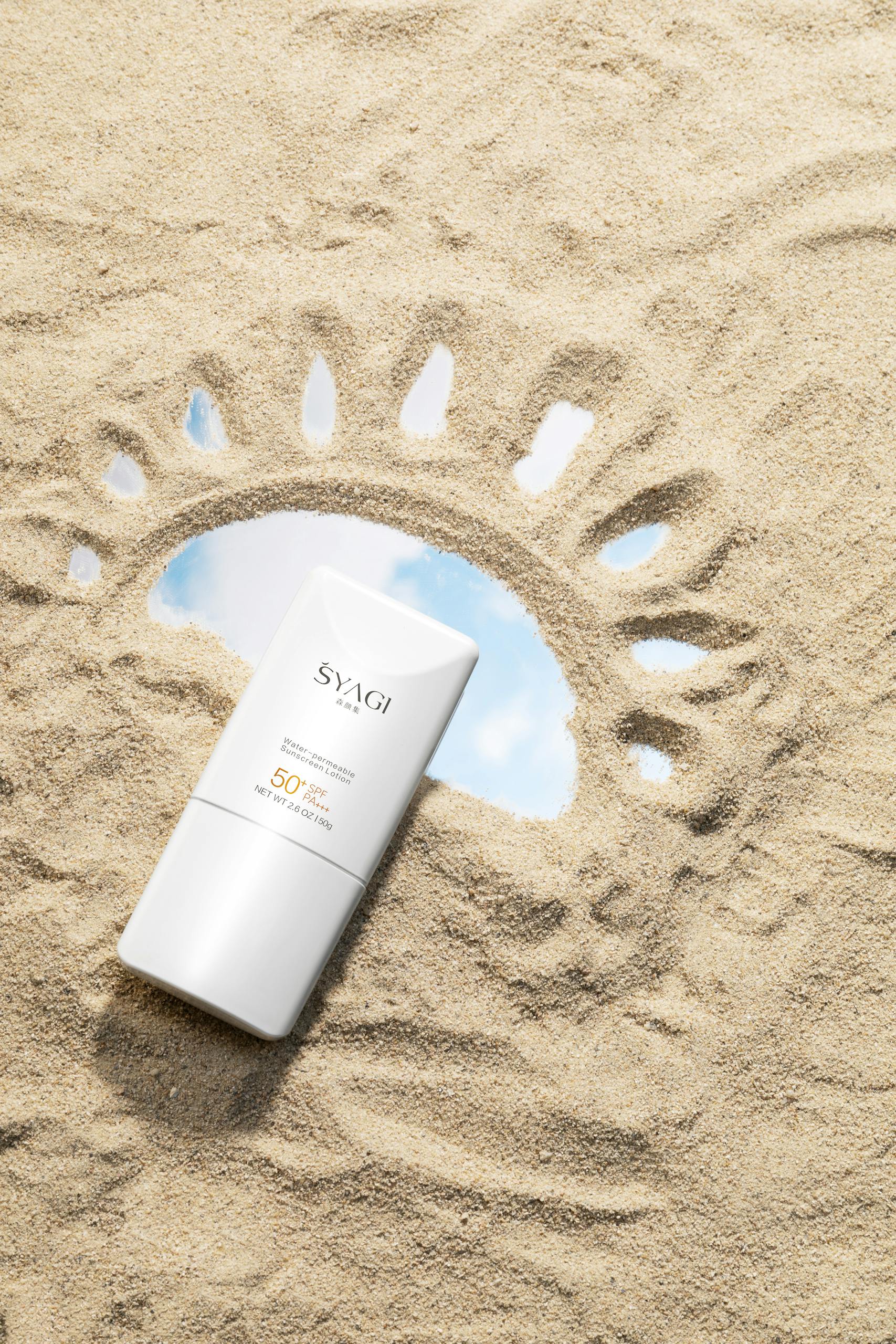 Sunscreen bottle nestled in sand with a sunburst pattern, highlighting SPF 50 protection.