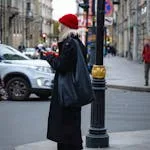 Stylish woman in red beret crossing a street in Saint Petersburg, Russia. Urban fashion and travel.